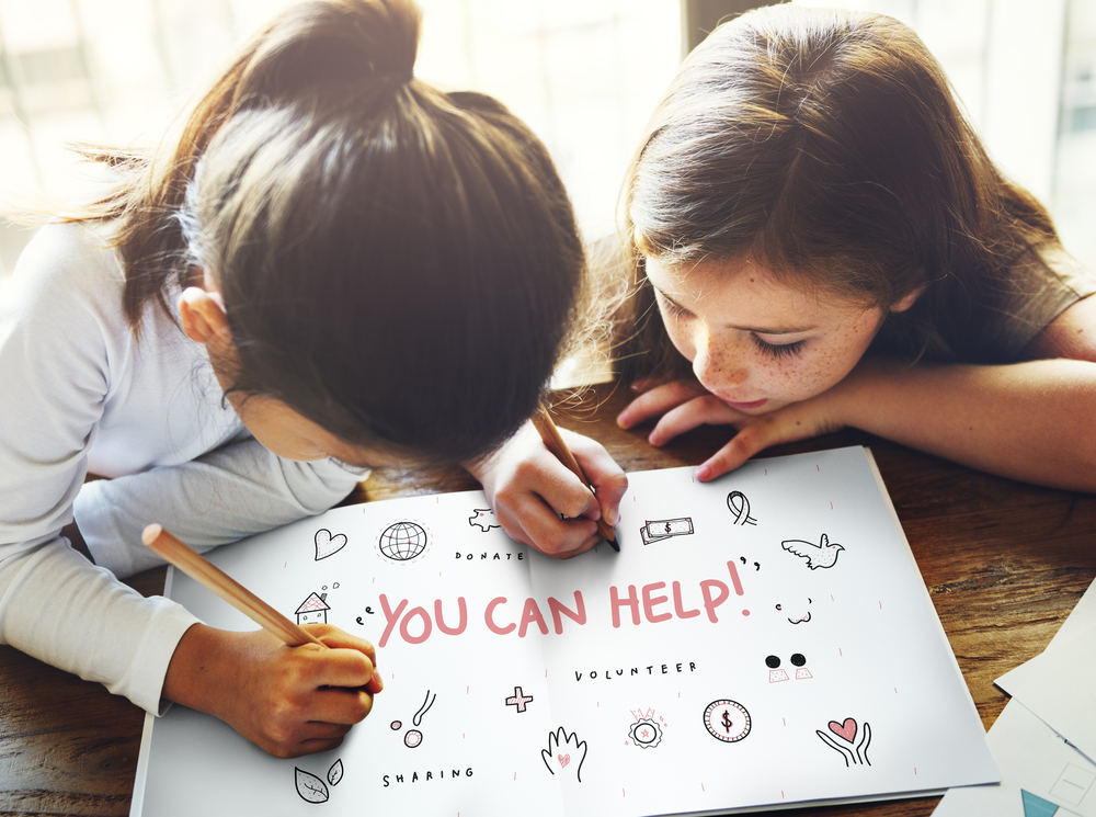 two kids drawing a picture that says you can help support charitable organizations