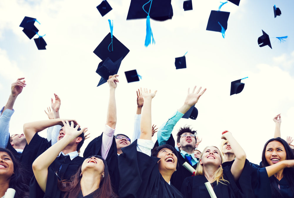 students throw their hats after using college savings plan to graduate