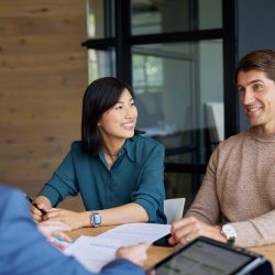 Young mixed race couple discussing financial plans with advisor. Female financial advisor guiding multiethnic couple on investment strategies. Chinese woman and mid adult man meeting with bank manager for investment.